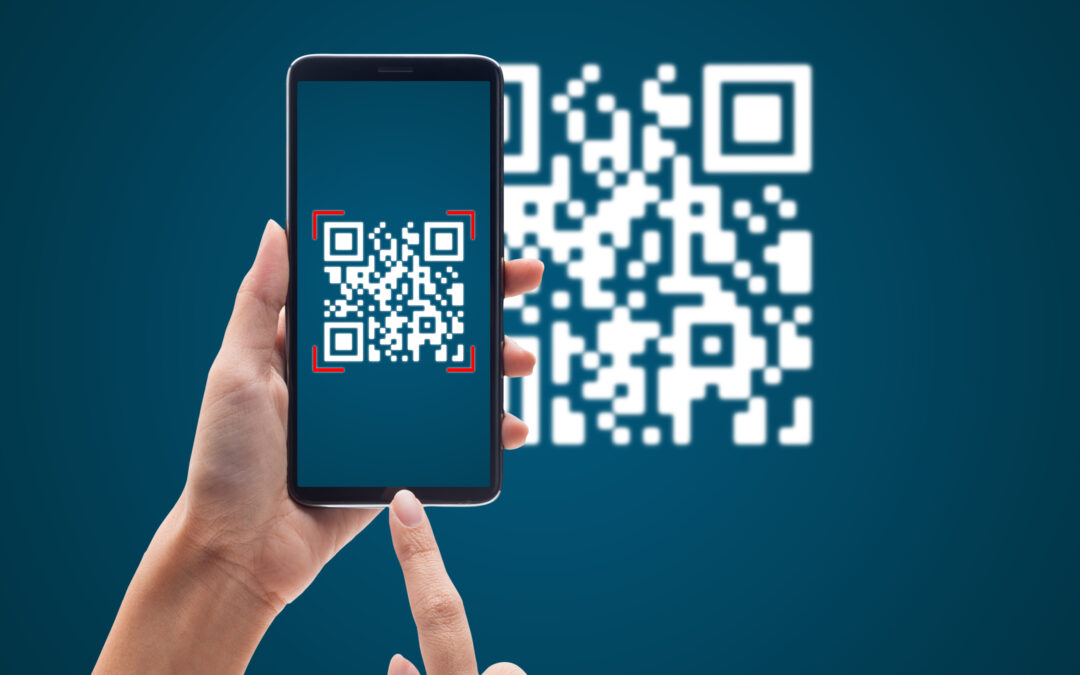 persona che inquadra un qrcode di pagamento con il proprio smartphone tenuto in mano