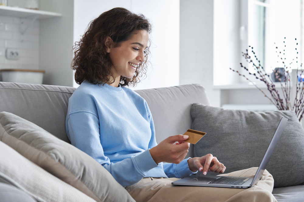 Donna sorridente che effettua un pagamento online con carta di credito
