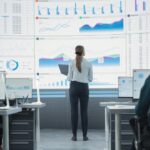 donna in piedi di fronte ad un enorme schermo pieno di dati